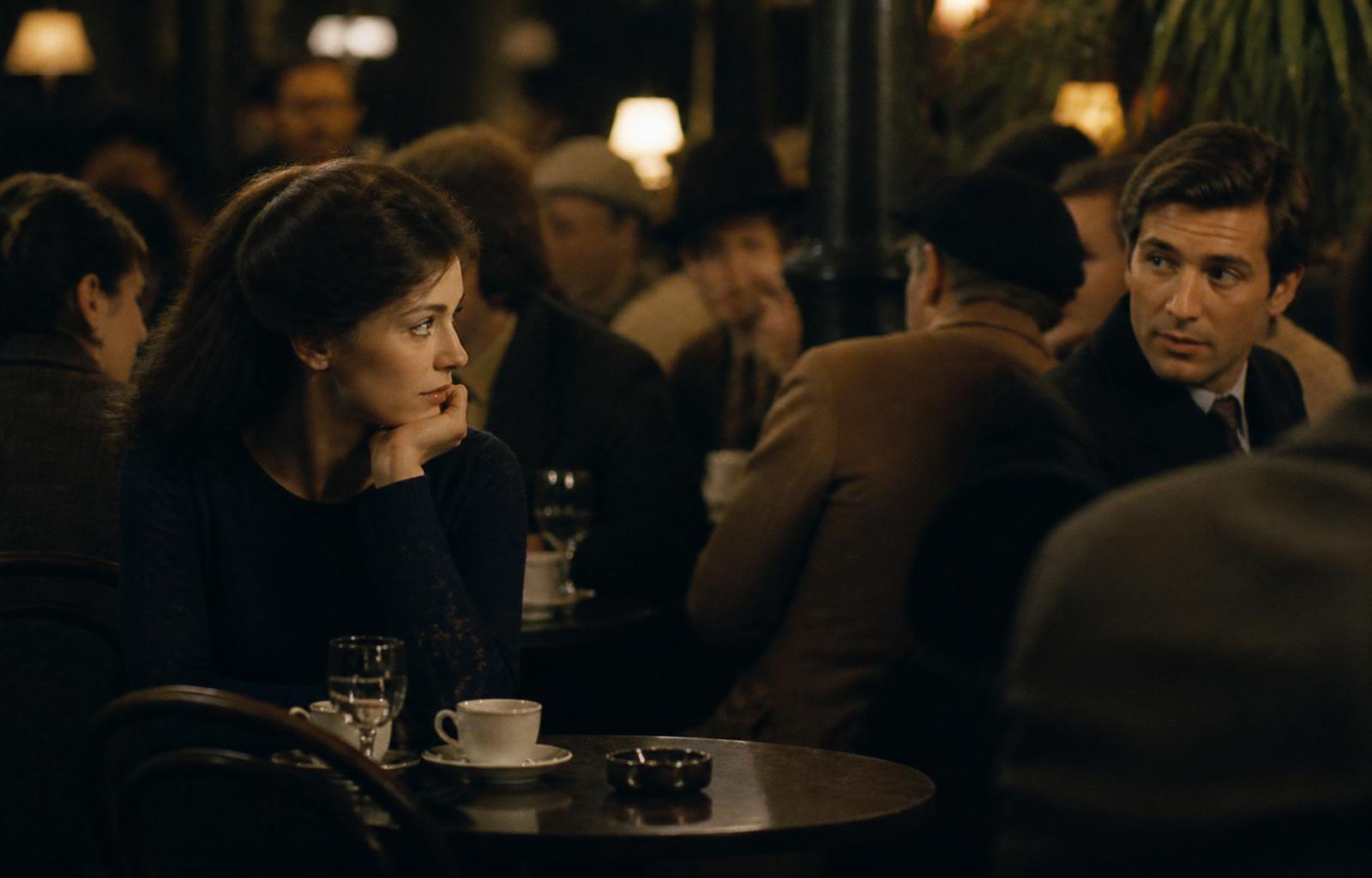 Two strangers noticing each other across a crowded cafe